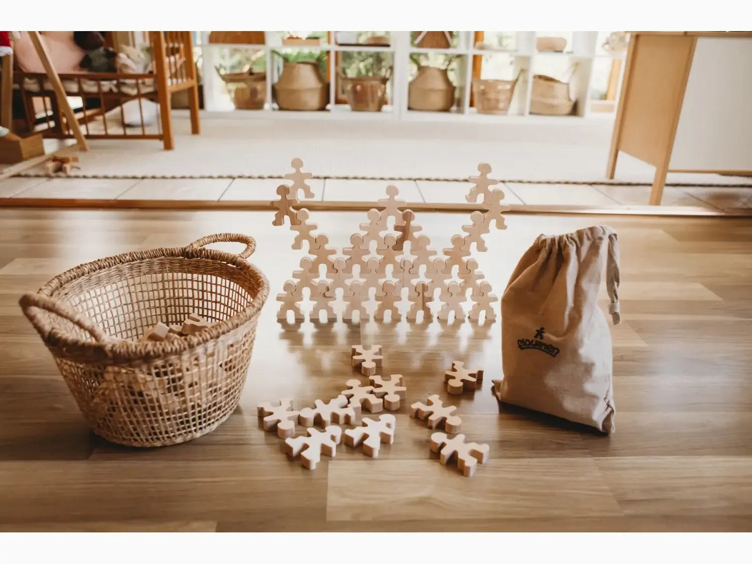 Wooden puzzle pieces arranged in a stacked formation on a floor.