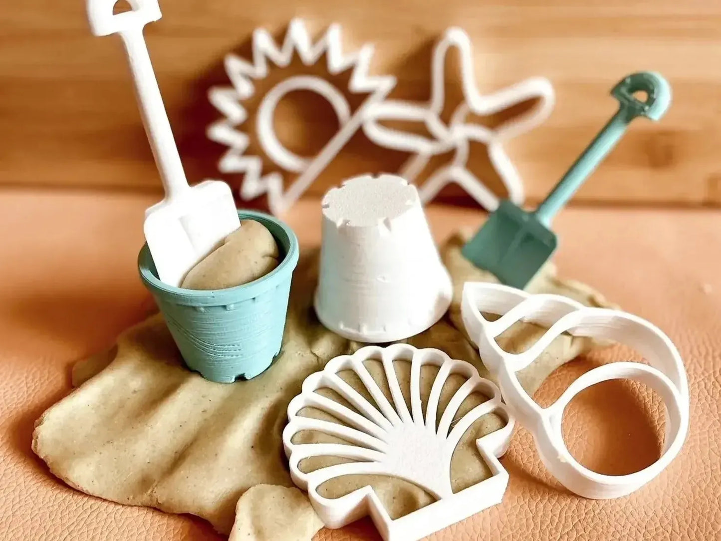 Collection of beach-themed miniature toys and molds for sand play.