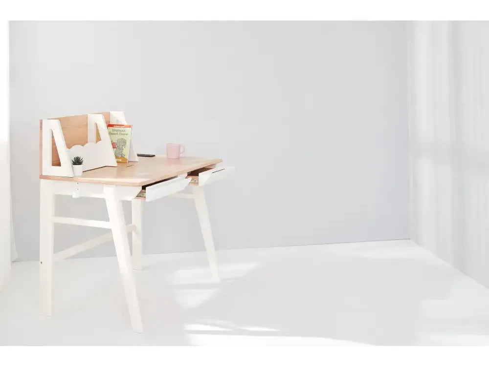 Minimalist white desk with an angled top and built-in storage compartment.
