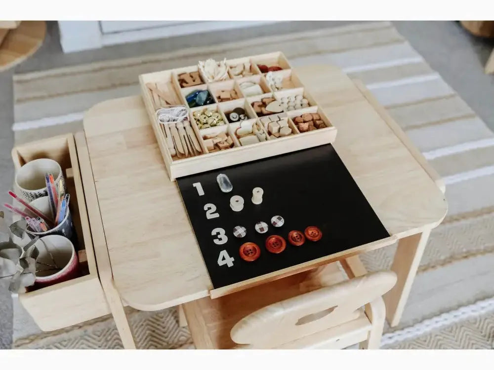 Wooden table with compartments for organizing small objects and a black surface for counting or learning activities.