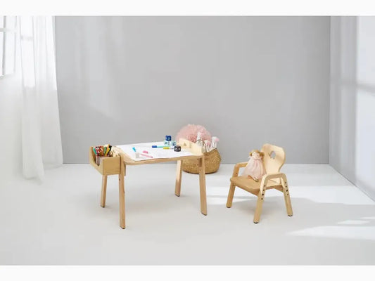 Wooden children’s desk and chair set with art supplies on the tabletop.