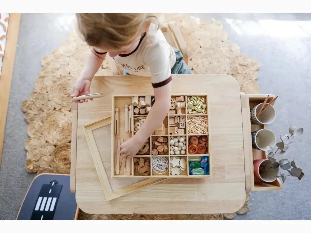 Wooden box with compartments containing various small objects and materials.