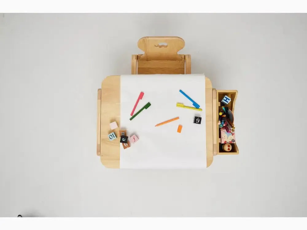 Wooden children’s desk with attached chair and storage compartments, featuring a white drawing surface and colorful art supplies.