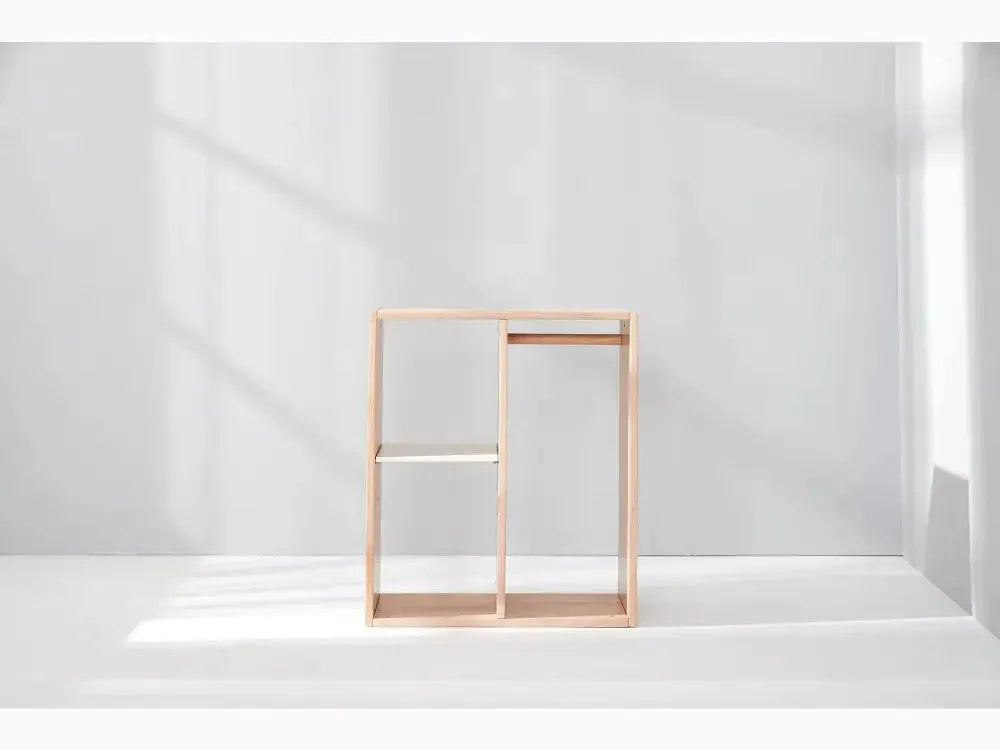 Minimalist wooden shelving unit with open rectangular compartments.