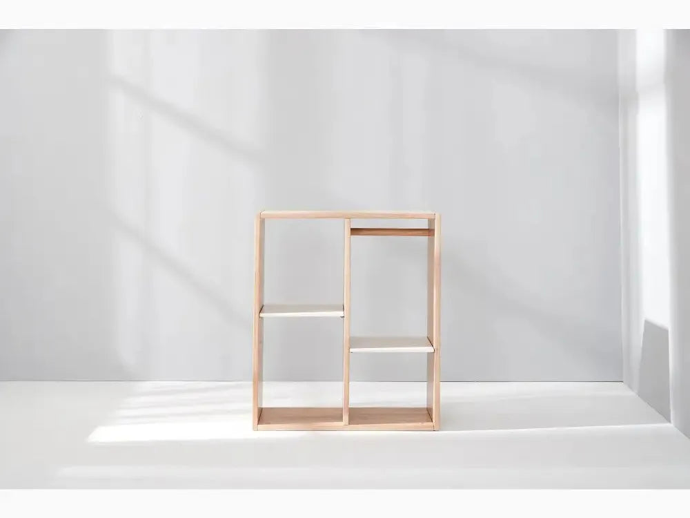 Minimalist wooden shelving unit with open rectangular compartments.