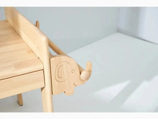 Wooden children’s chair with an elephant-shaped armrest.