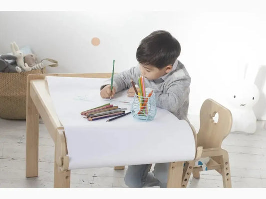 Child-sized wooden desk and chair set designed for drawing or writing activities.