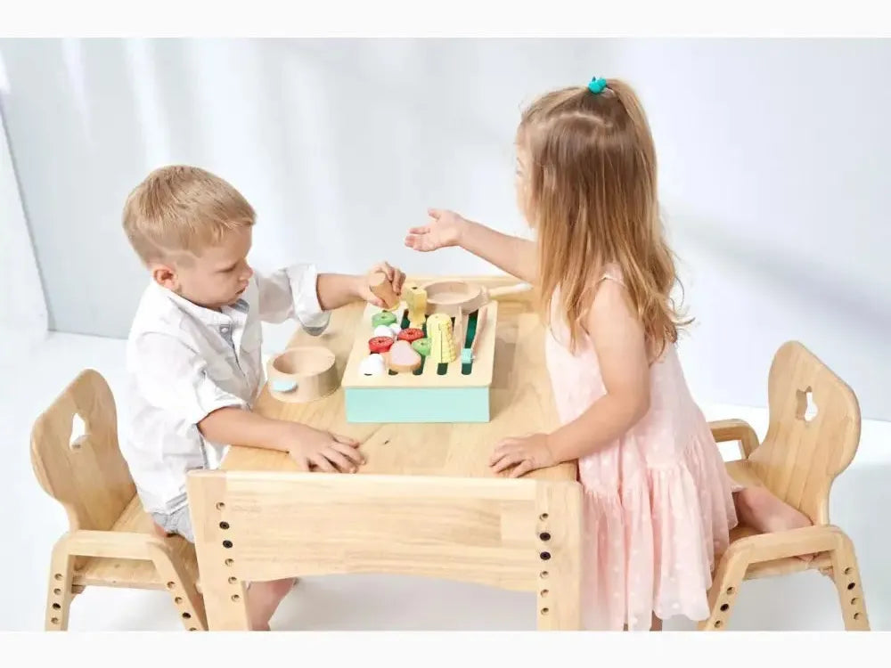 Wooden children’s table with two chairs and a colorful toy on top.