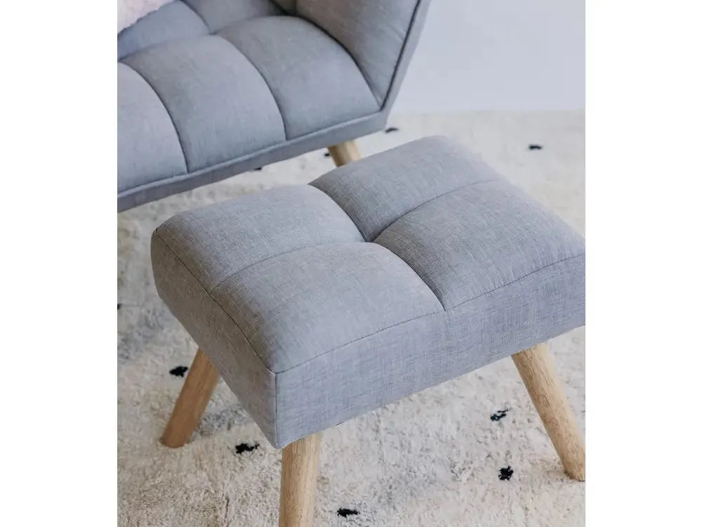 Gray upholstered armchair with matching footstool on wooden legs.