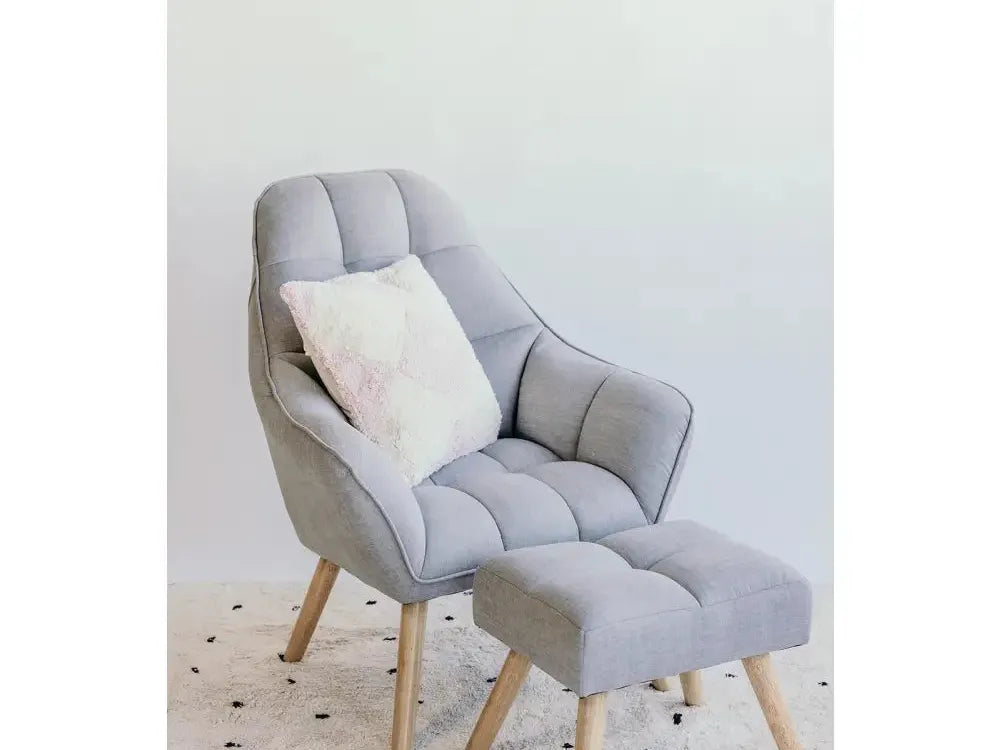 Comfortable-looking gray armchair with matching footstool and decorative pillow.