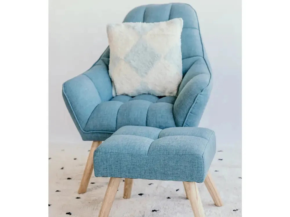 Light blue upholstered armchair with matching footstool and decorative pillow.