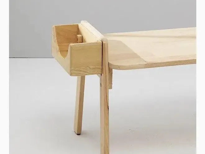 Minimalist wooden bench with a curved backrest and tapered legs.