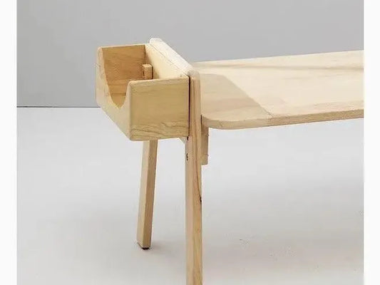 Minimalist wooden bench with a curved backrest and tapered legs.