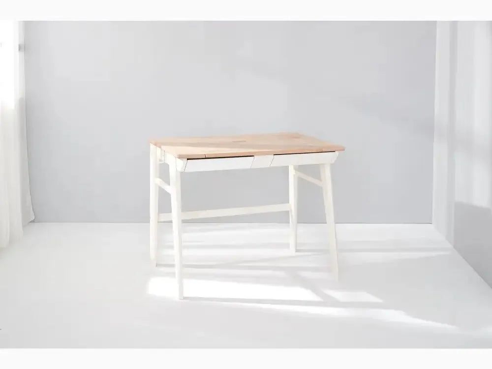 Simple wooden desk with white legs and a natural wood top.