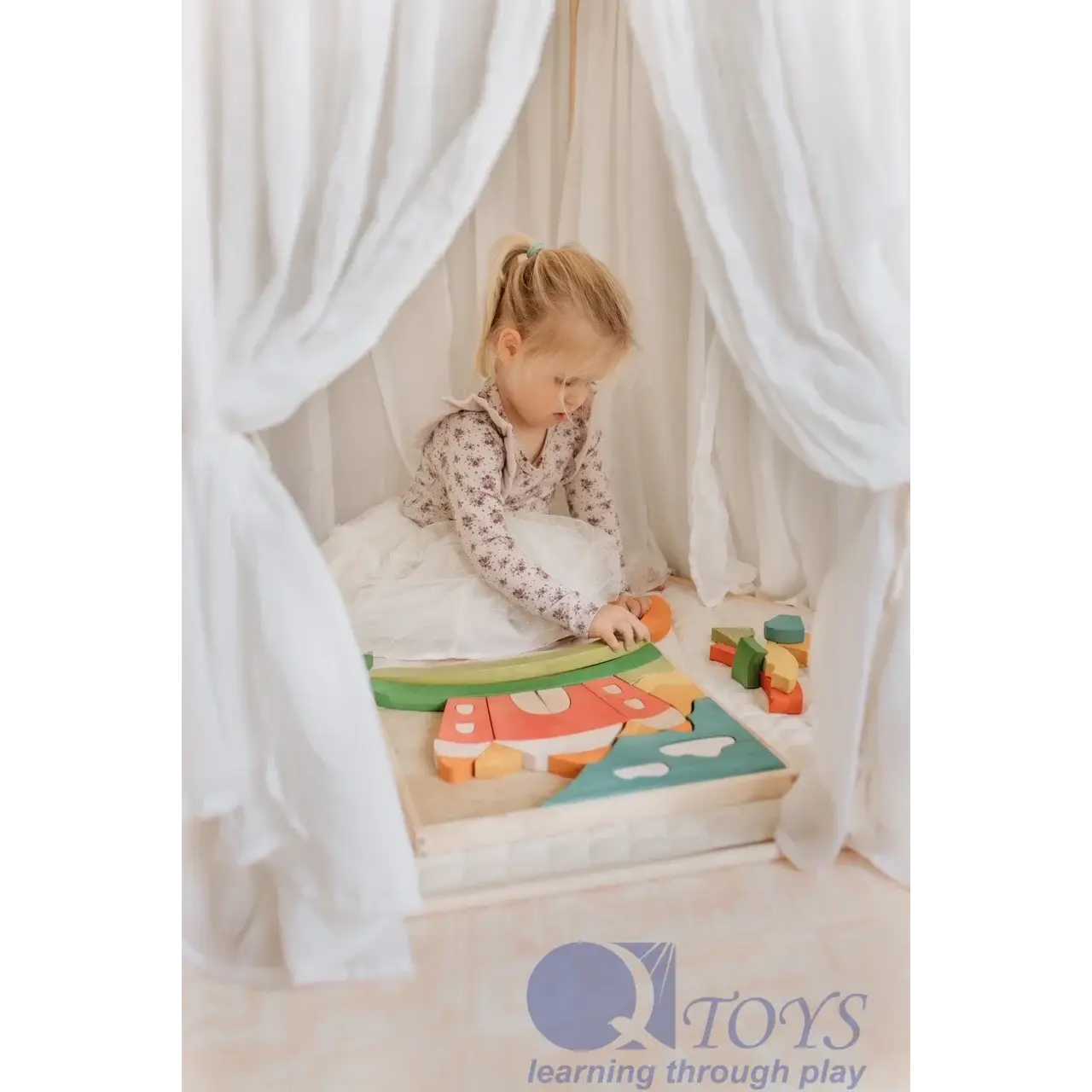 Child playing with a wooden puzzle or shape-sorting toy.
