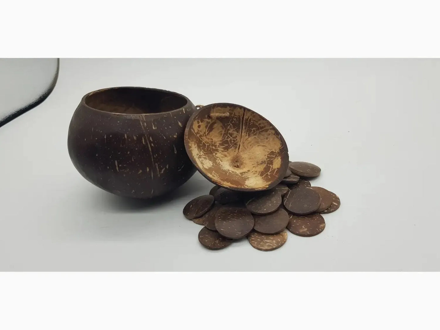 Coconut shell bowl with scattered chocolate coins nearby.