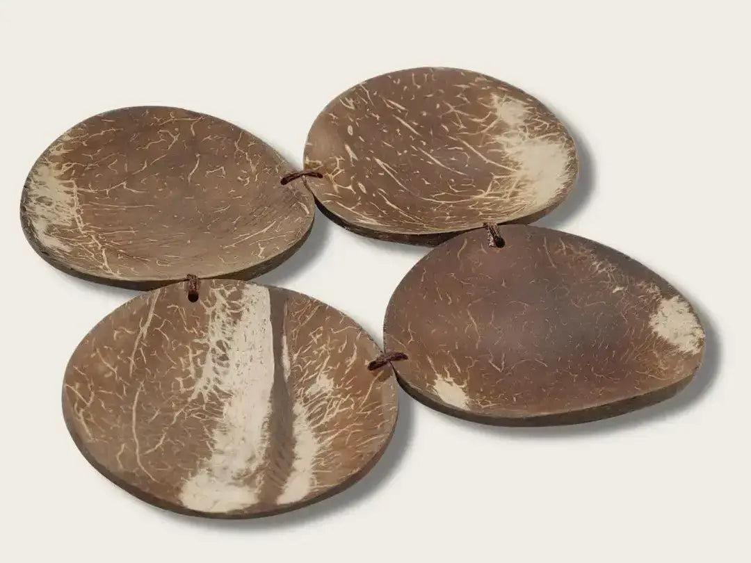 Coconut shell pieces shaped into flat, oval discs.
