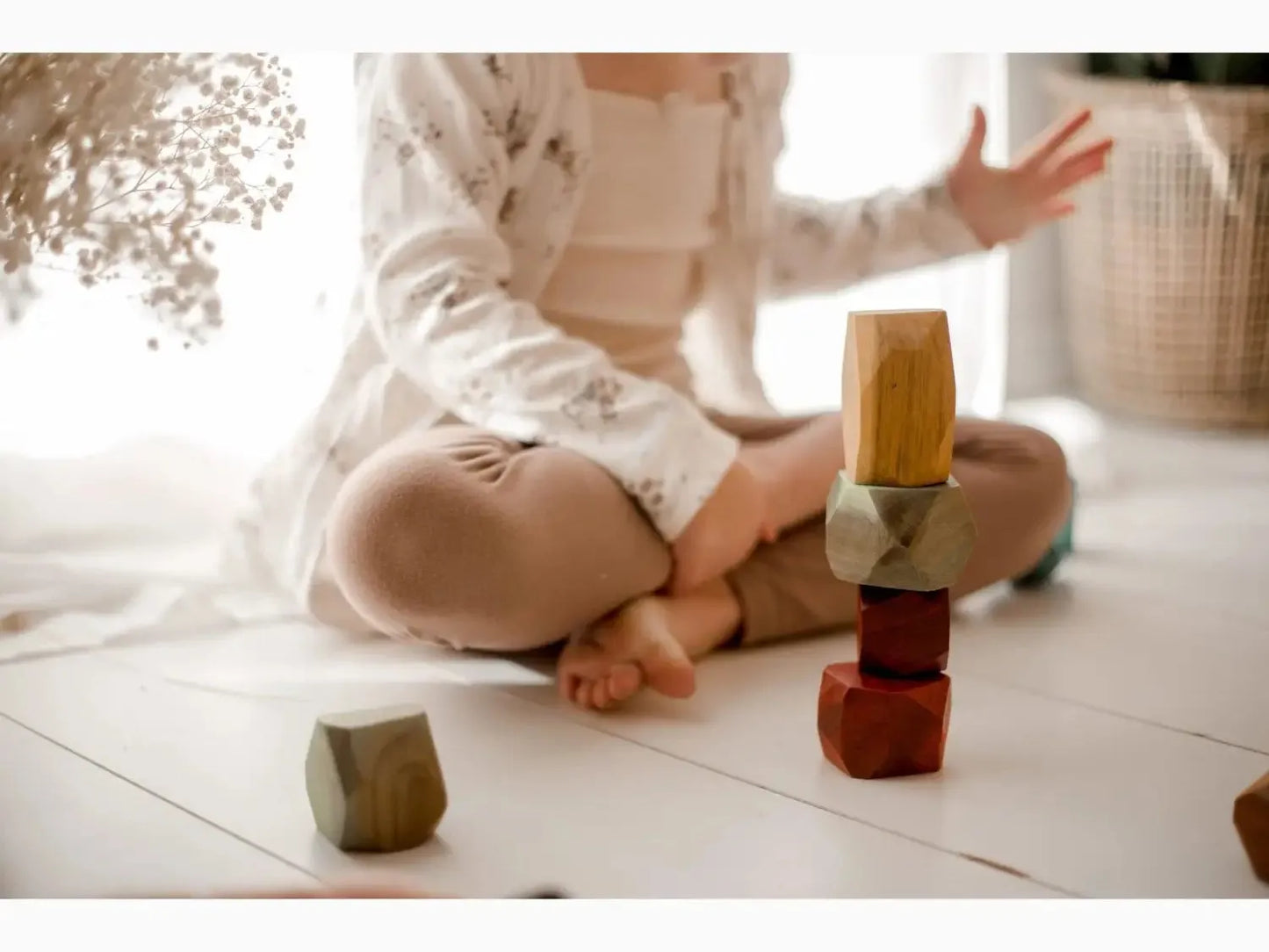 Wooden blocks stacked in a small tower on a floor.