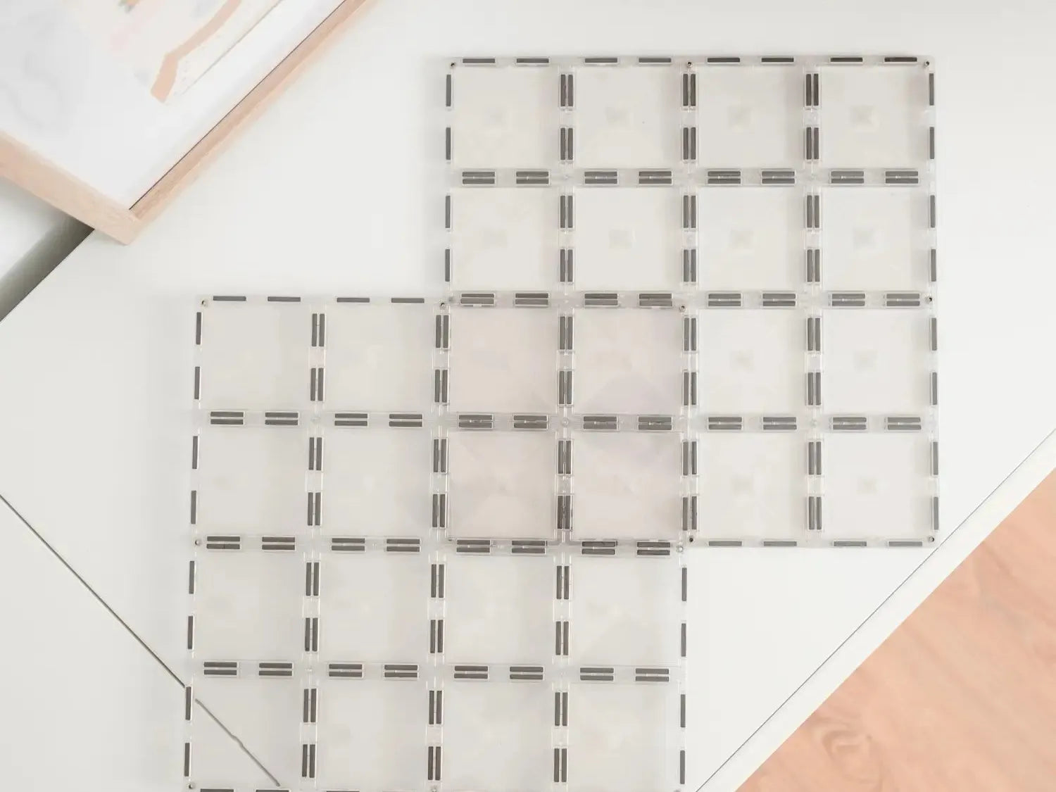 Grid-like pattern of dashed lines forming squares on a light surface.