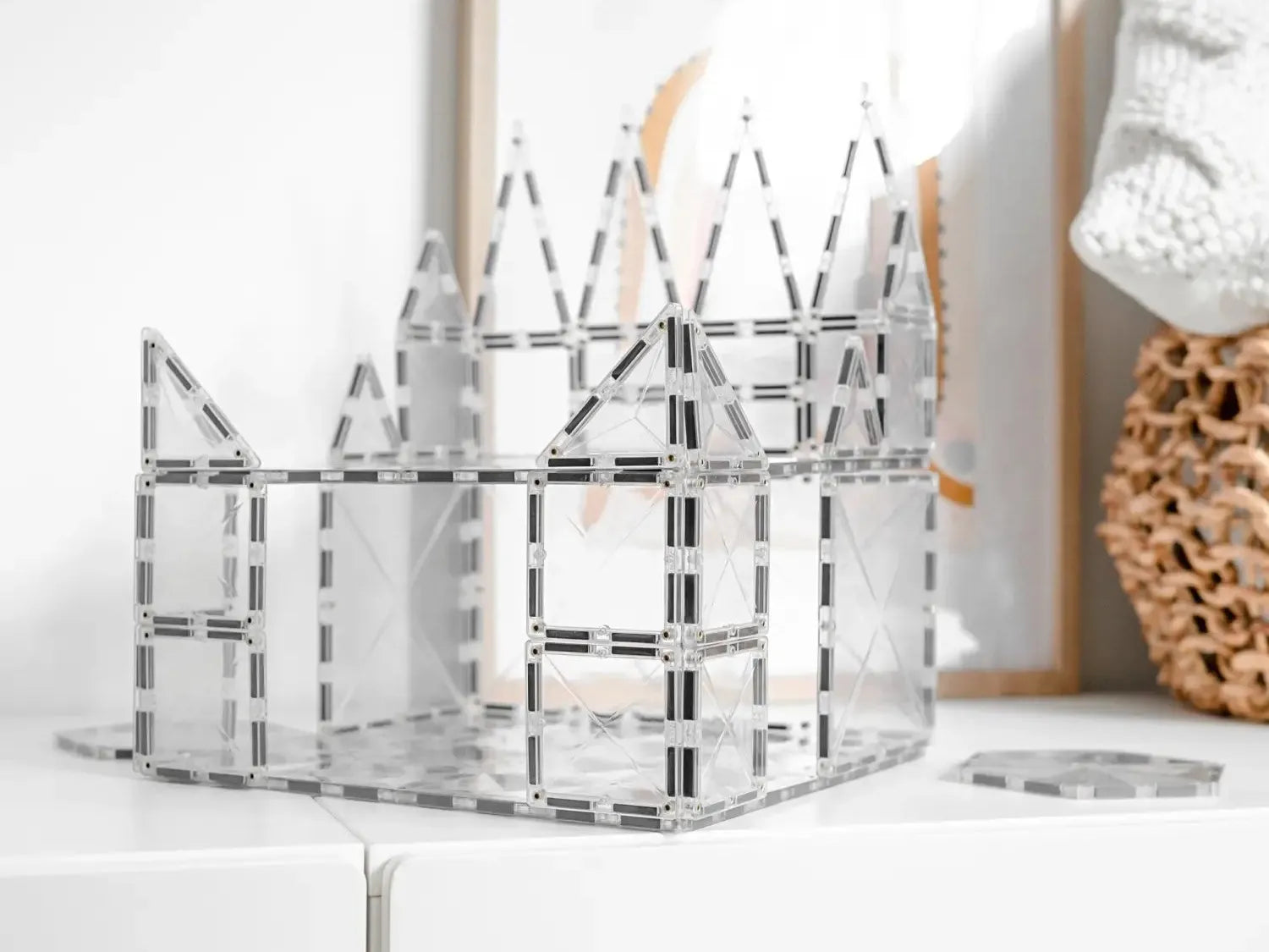Transparent acrylic or glass castle-shaped organizer with geometric cutout patterns.