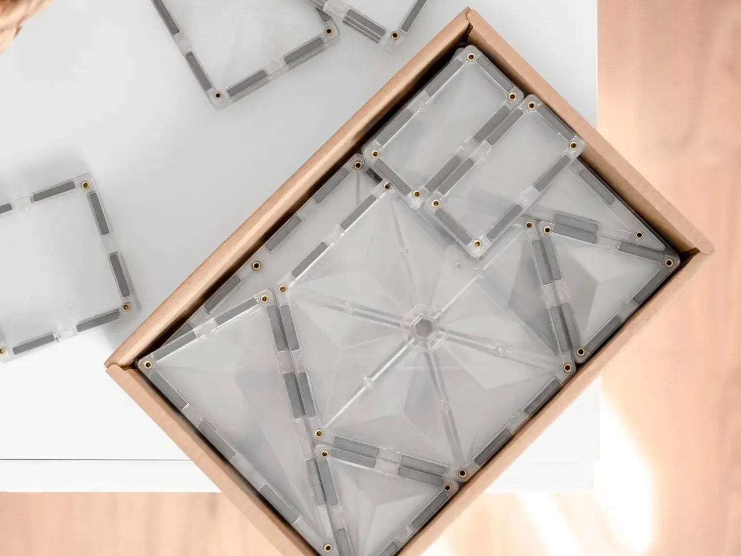 Wooden box containing metal rods arranged in geometric patterns.