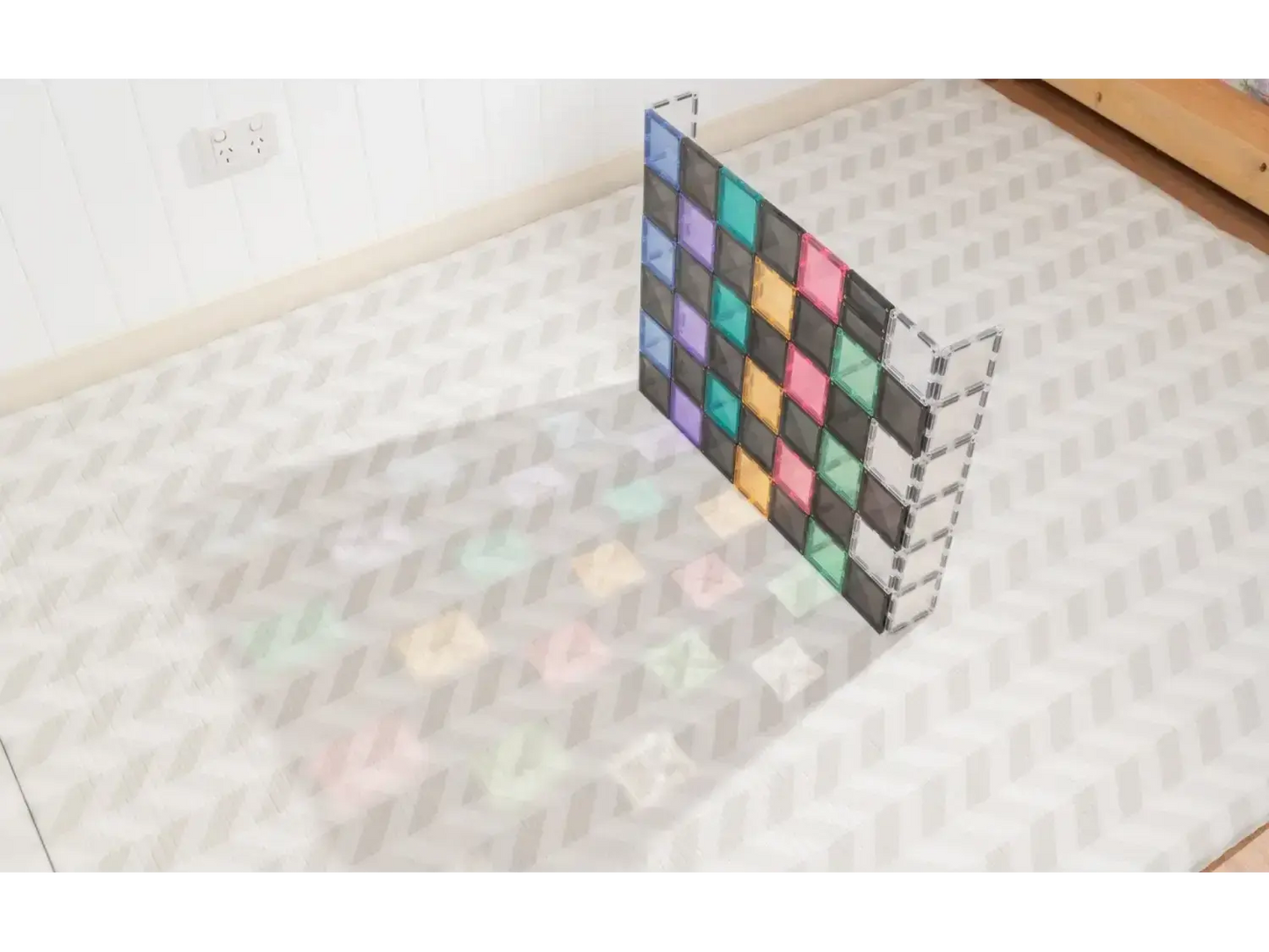 Colorful geometric grid structure casting a rainbow-like shadow on a tiled floor.