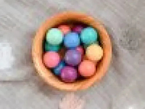 Bowl filled with colorful round objects, likely candies or small balls.