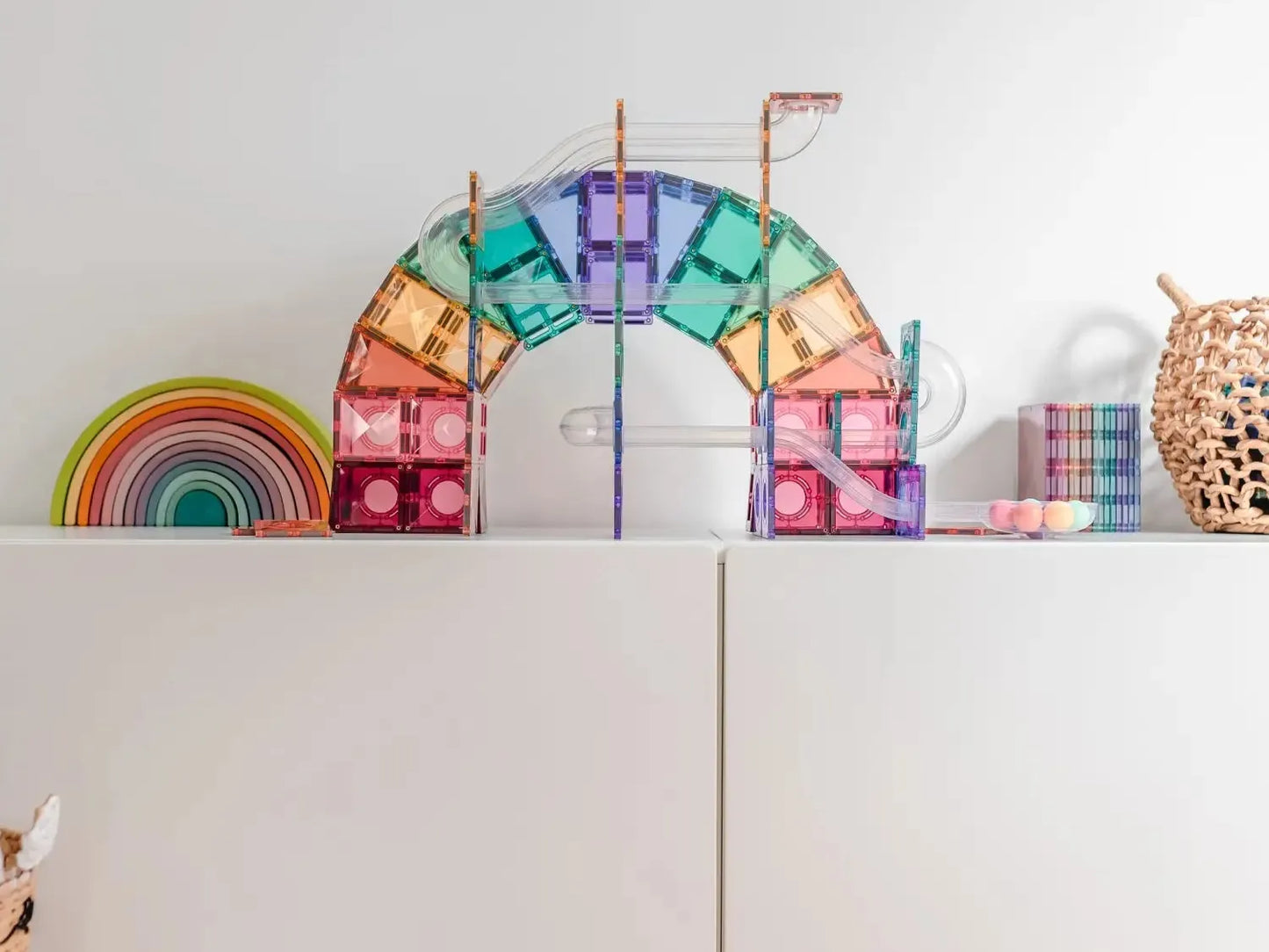 Colorful magnetic building tiles arranged in an arch shape.