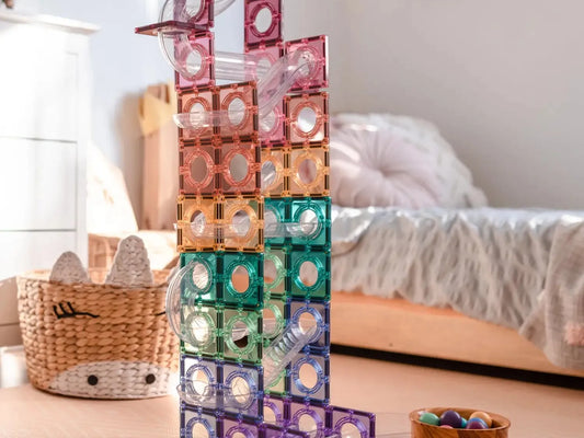 Colorful magnetic building tiles stacked into a tall structure.