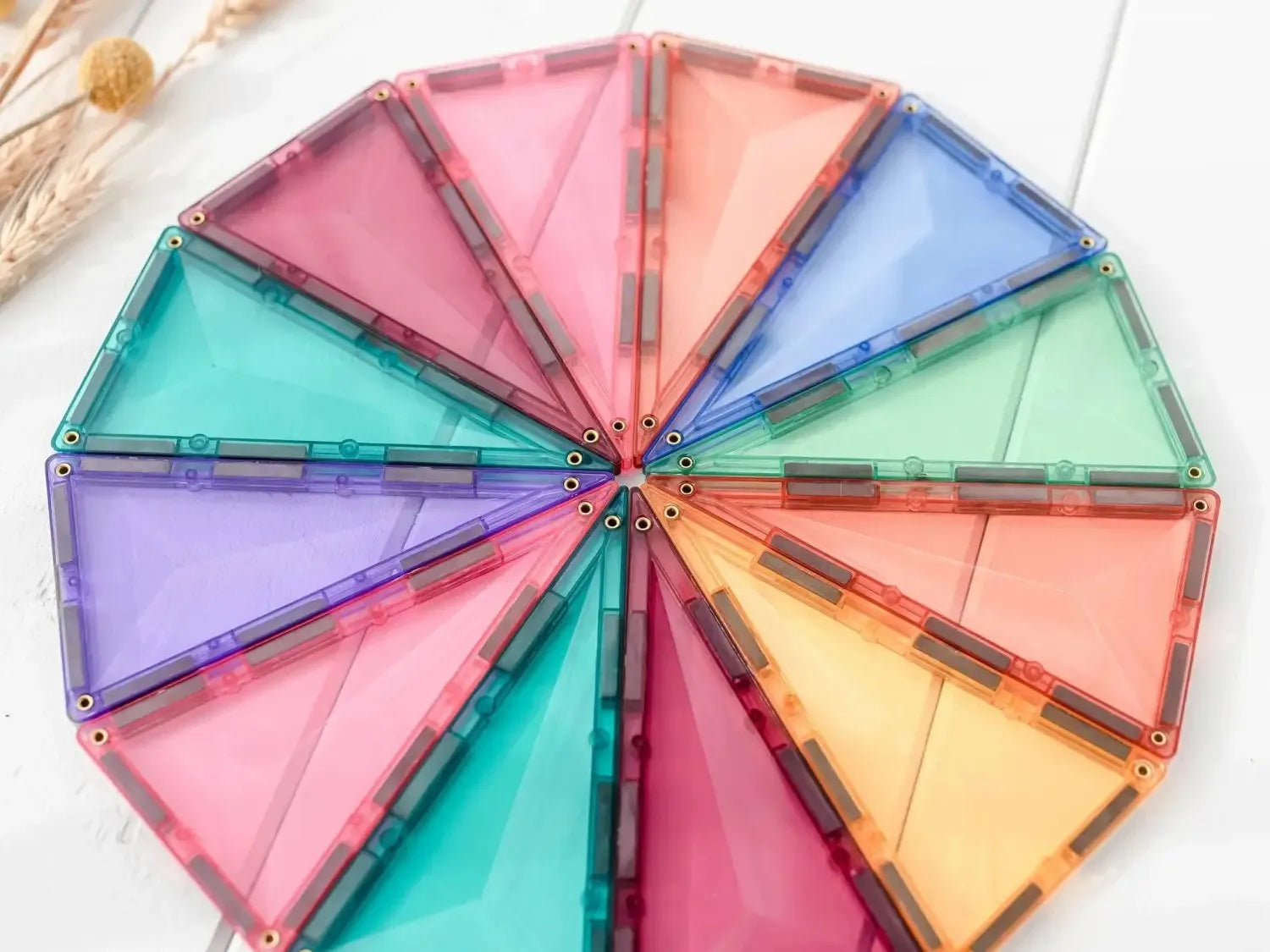 Colorful circular arrangement of triangular magnetic tiles forming a wheel-like shape.