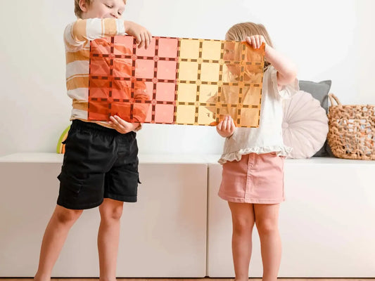 Colorful interlocking wooden block set held by two children.