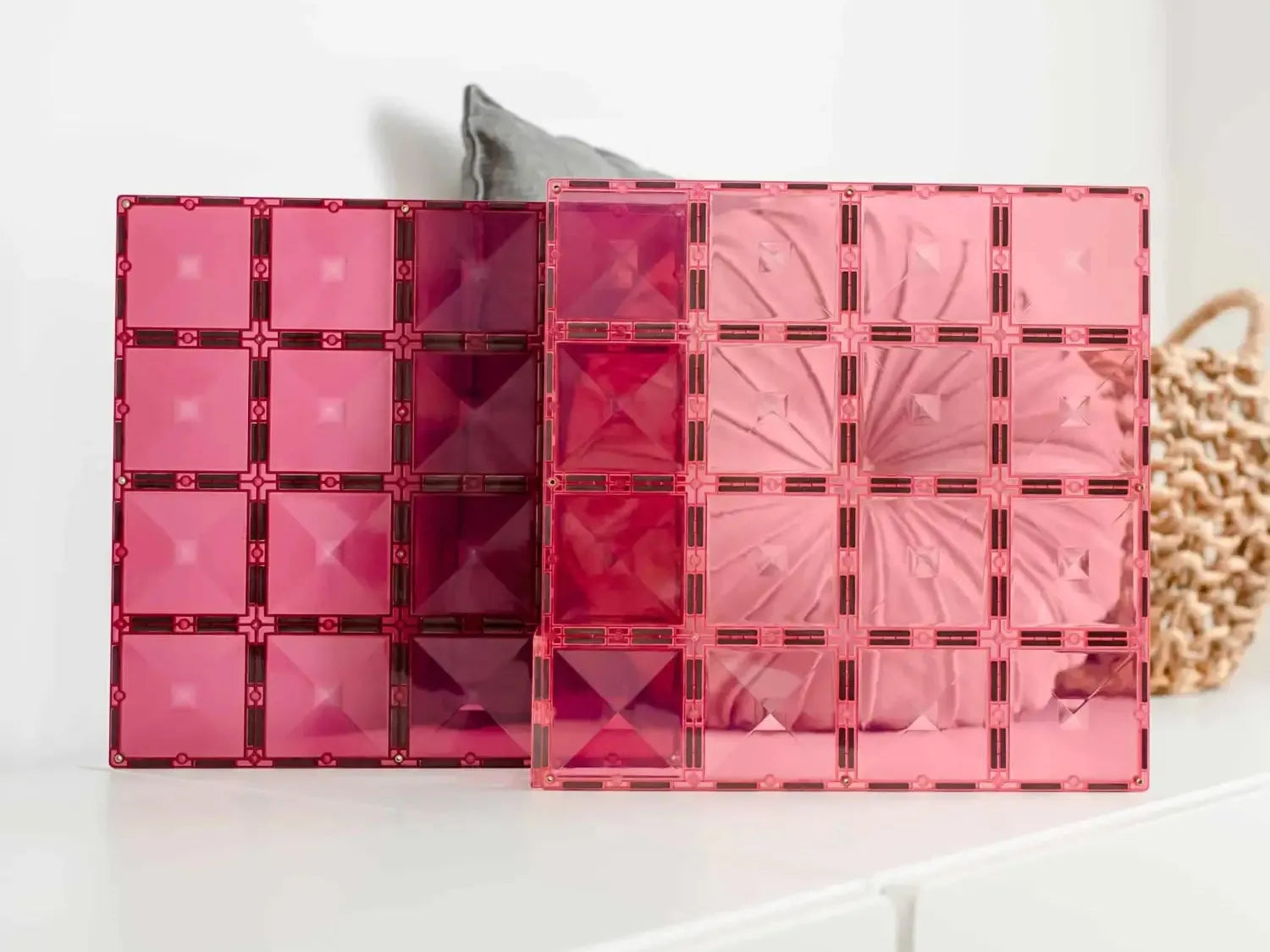 Set of pink and red transparent acrylic or plastic storage organizers with grid patterns.