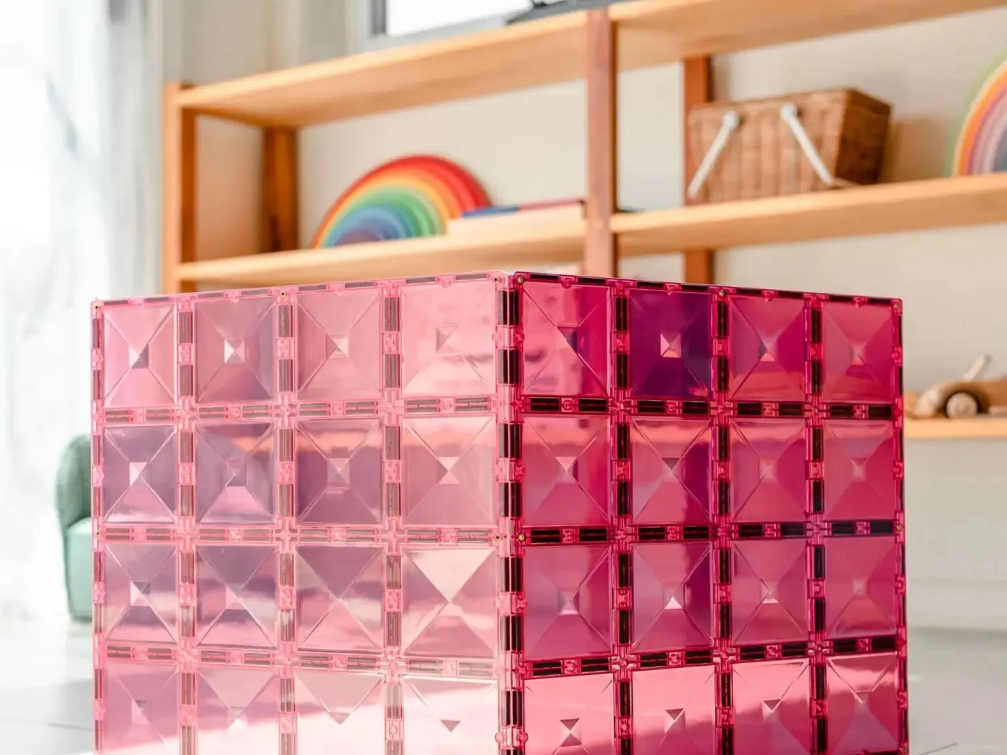 Pink translucent cube-shaped structure made of interconnected smaller cubes.