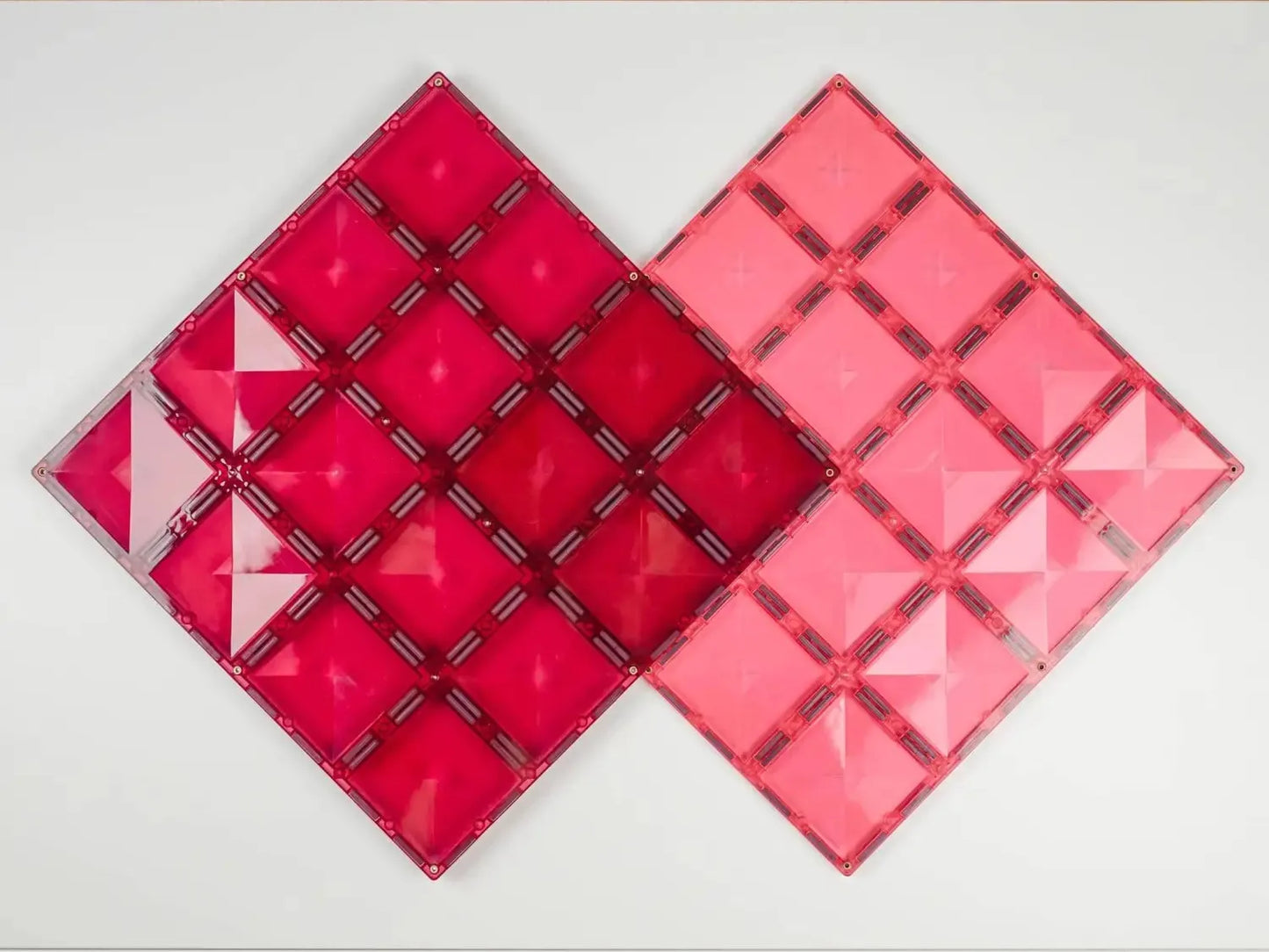 Two diamond-shaped geometric wall art pieces in shades of red and pink.