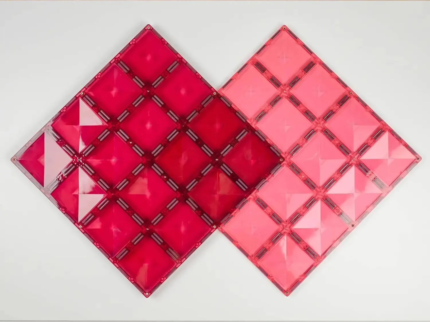 Two diamond-shaped geometric wall art pieces in shades of red and pink.