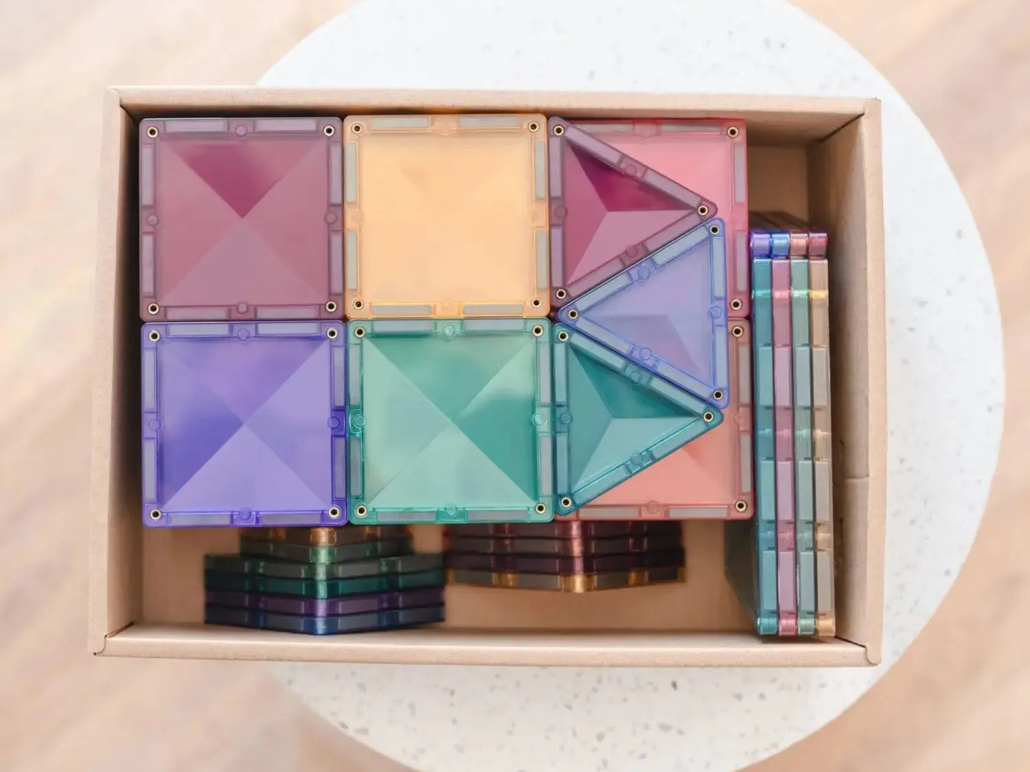 Colorful magnetic building tiles set in a storage box.