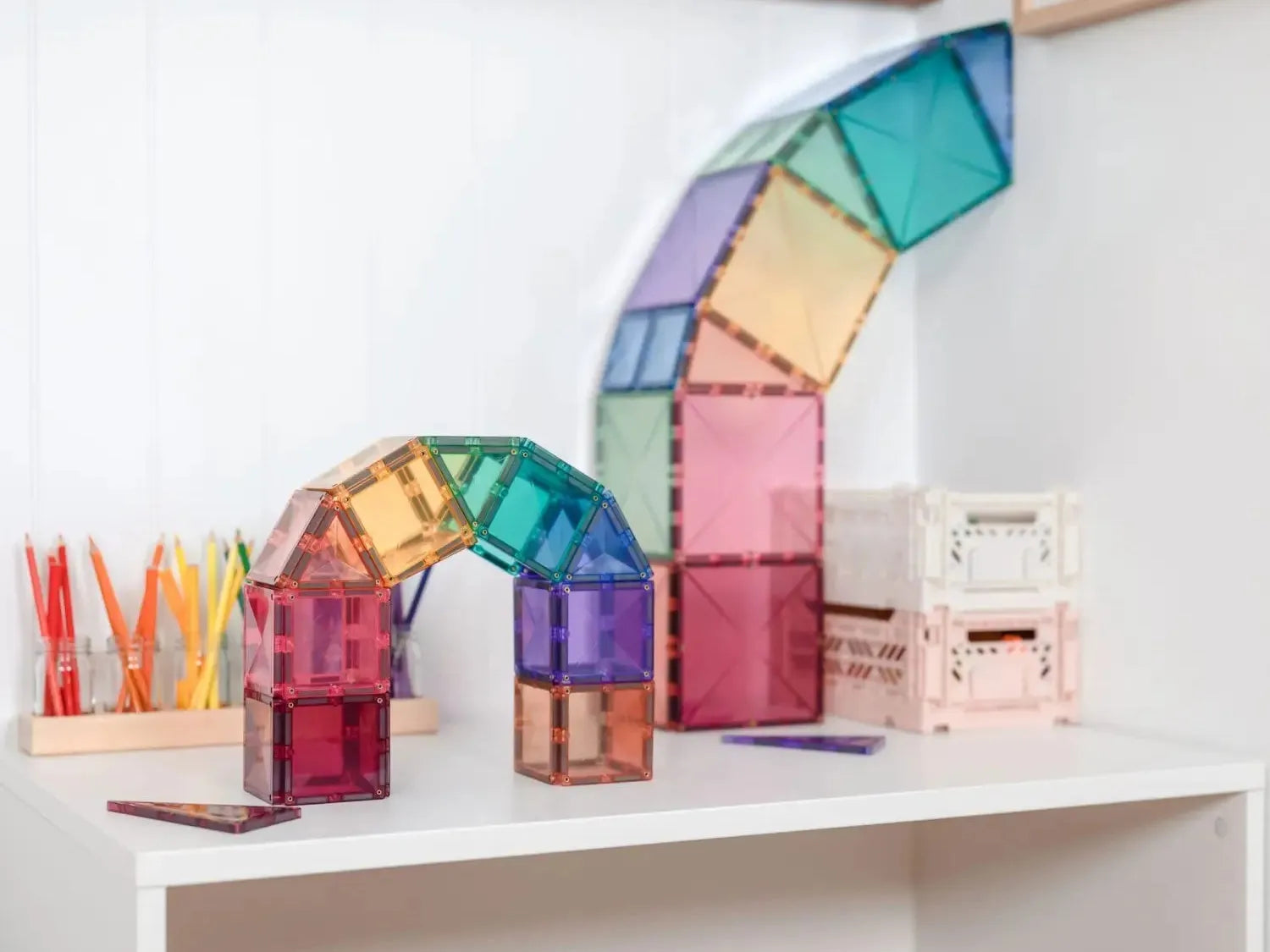 Colorful magnetic building tiles arranged in an arched structure.