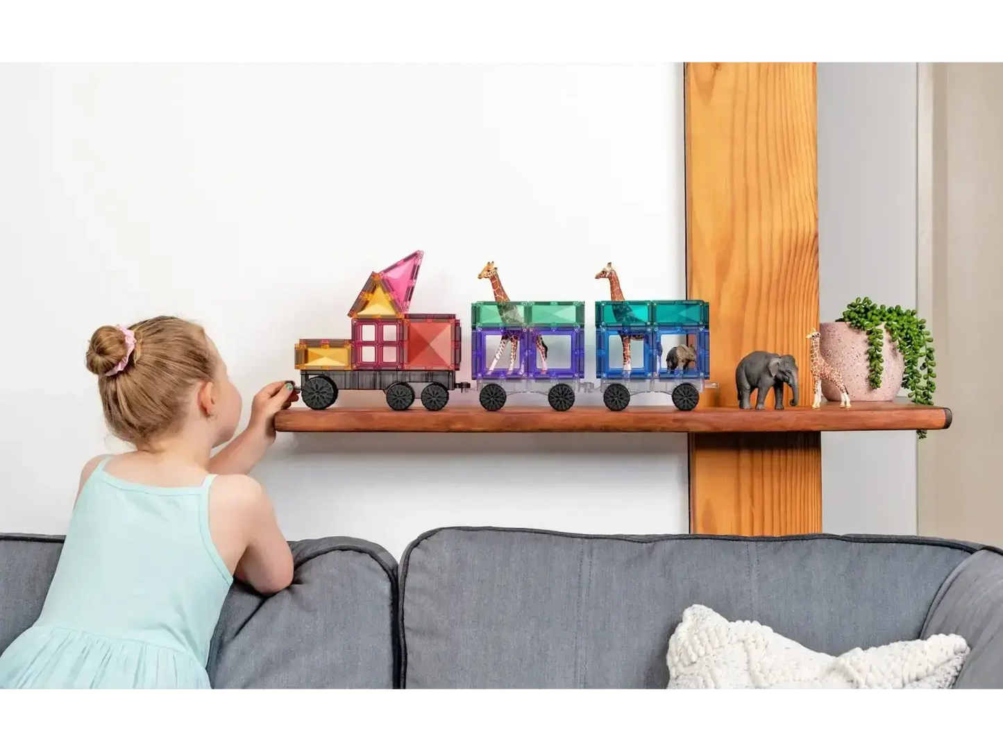 Colorful wooden toy train with various shapes and animals on a shelf.