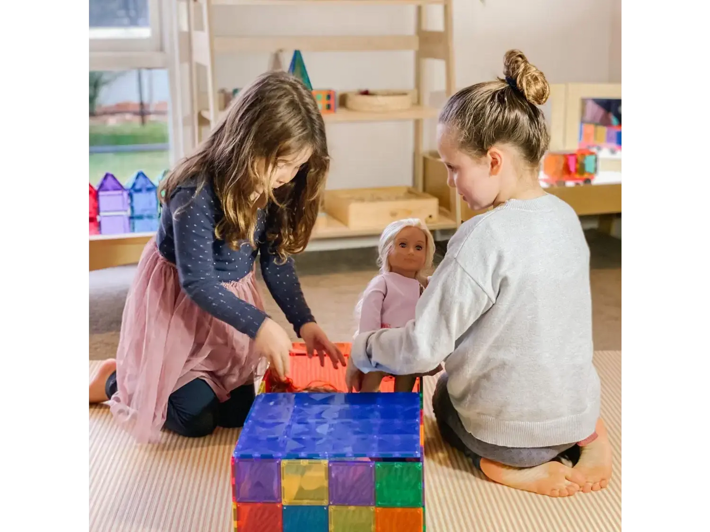 Two children playing with colorful building blocks on a carpeted floor.