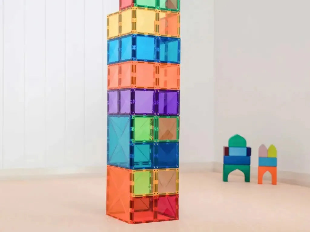 Colorful stack of transparent magnetic building tiles forming a tall tower.