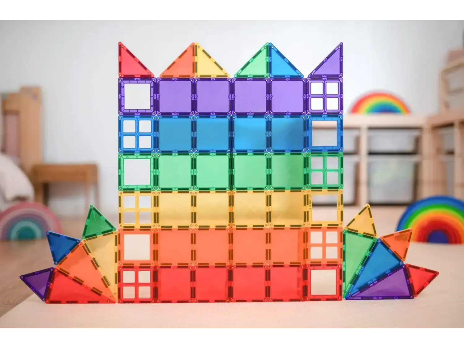 Colorful magnetic tile construction forming a rainbow-hued castle-like structure.