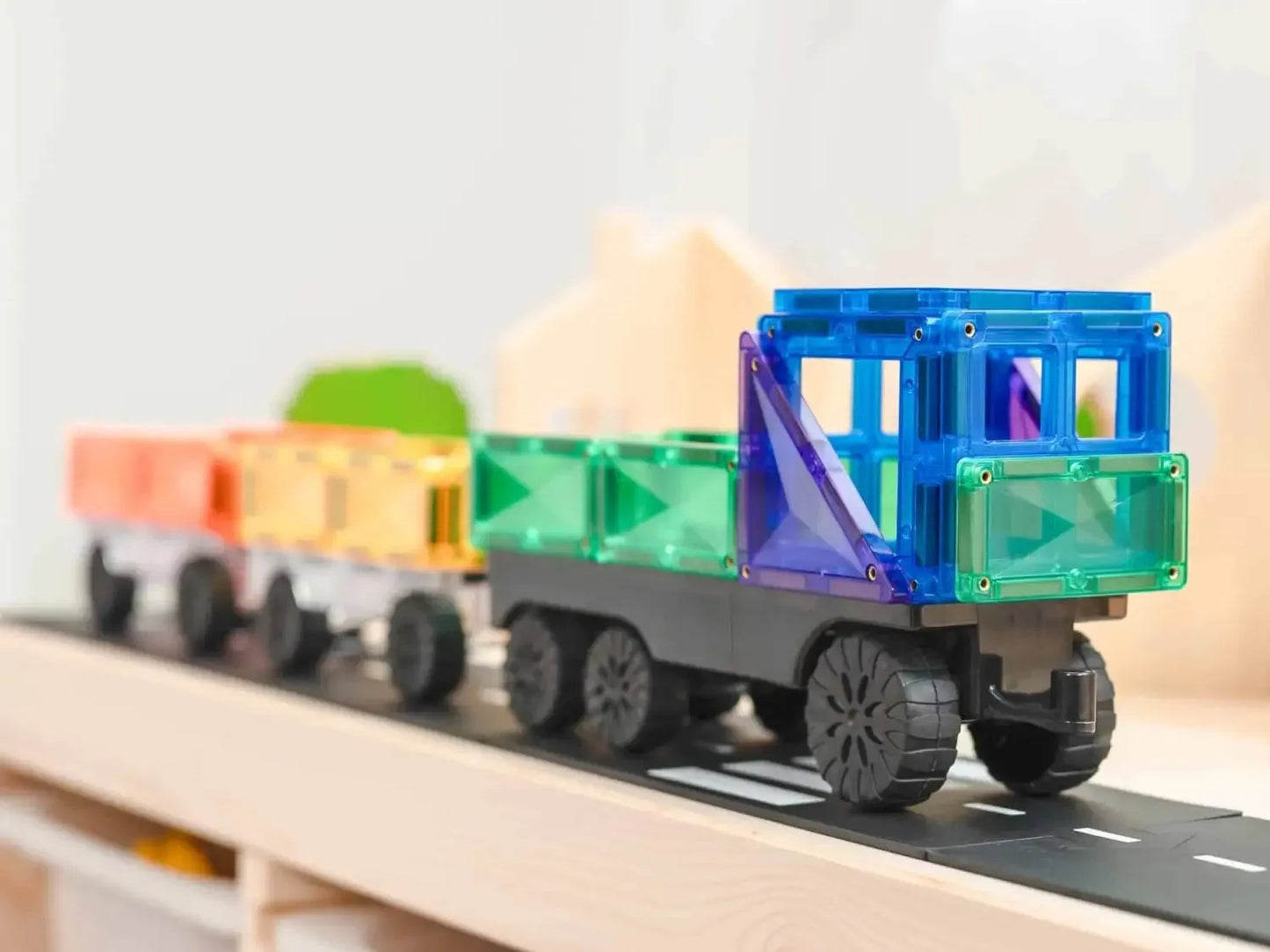 Colorful toy train made of magnetic building blocks on a track.