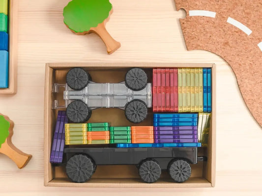 Wooden toy train carrying colorful blocks in its cargo car.