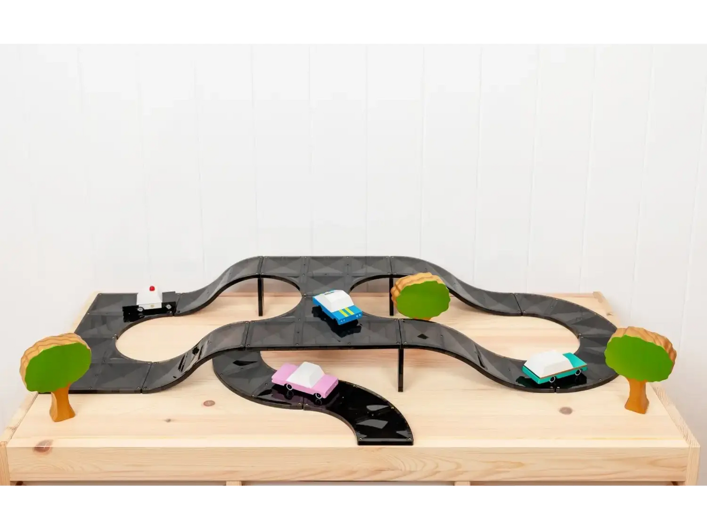 Wooden toy car track with miniature vehicles and trees.
