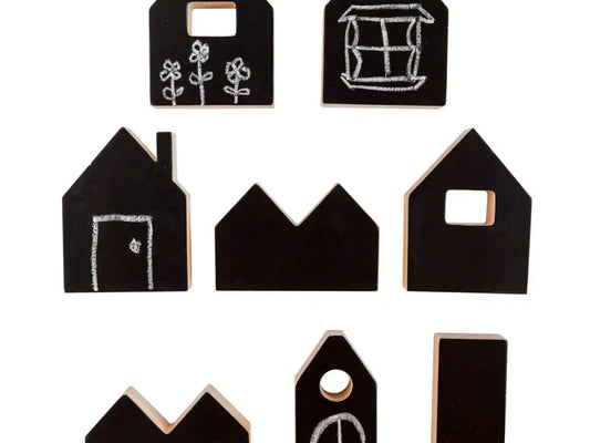Set of black wooden house-shaped blocks with simple chalk-like drawings on them.