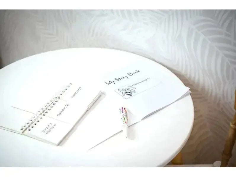 White circular table with wedding planning documents and a pen.