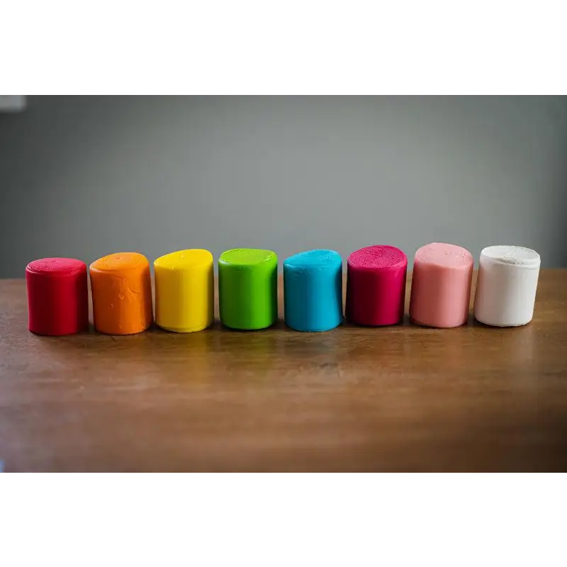 Row of colorful cylindrical objects arranged in a rainbow-like spectrum.