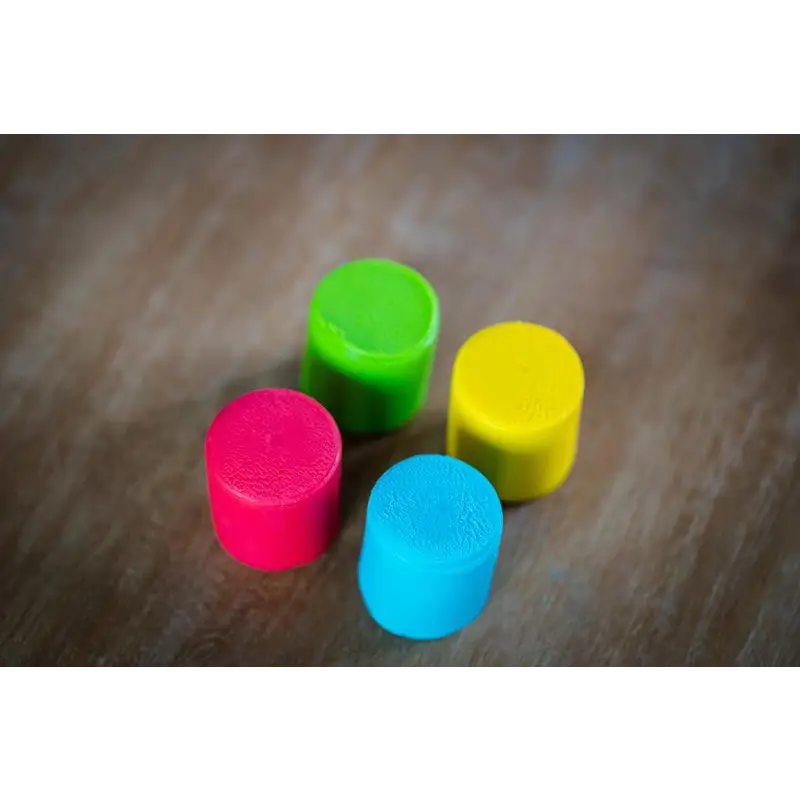 Colorful cylindrical blocks or tokens in bright neon shades.