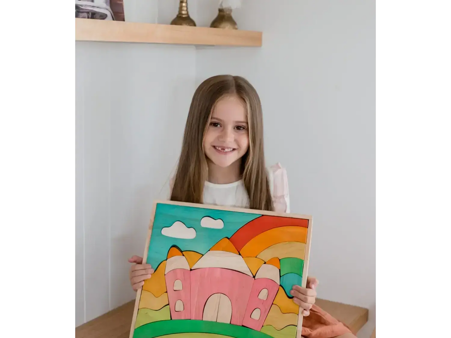 Colorful painting of a whimsical castle with a rainbow and clouds.