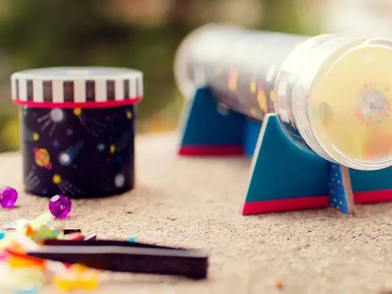 Colorful kaleidoscopes with decorative exteriors lying on a surface.